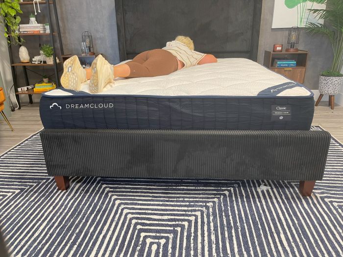 A woman lays on her stomach on the DreamCloud Memory Foam Mattress