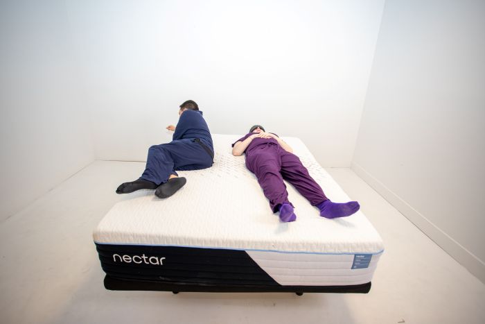 A man and a women testing couples motion isolation on the Nectar Classic Hybrid mattress.
