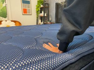 Our tester presses down on the DreamCloud Luxe Memory Foam mattress