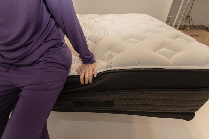 A close look as our tester pushes on the edge of a Nolah Evolution Mattress