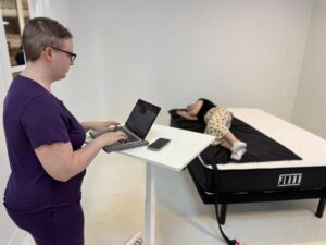 Melanie taking pressure map readings of the Plank Firm Mattress 1