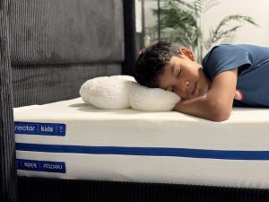 A young boy sleeping on the Nectar Kids mattress