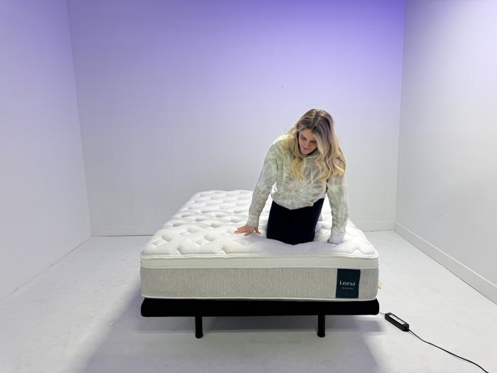 Our tester kneeling on the Leesa Sapira Chill Hybrid Mattress