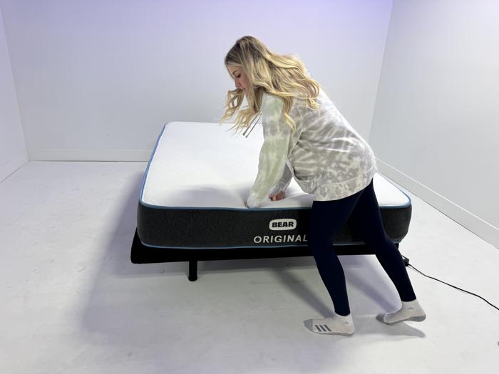 Our tester pressing firmly into the edge of a Bear Original Mattress
