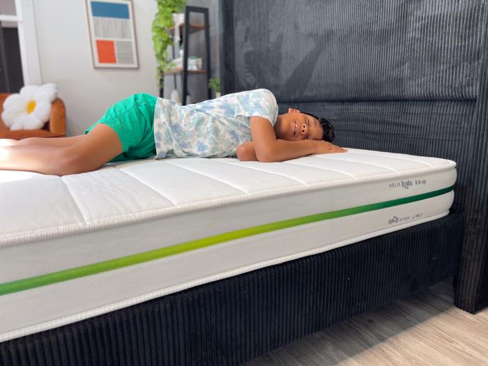Our young tester side-sleeping on a Helix Kids Mattress 1
