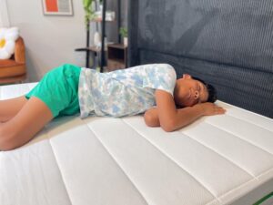 Our young tester side-sleeping on a Helix Kids Mattress 2