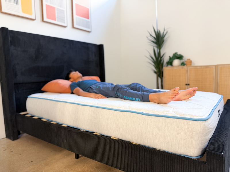 A young tester rests on his back on the Bear Cub mattress.