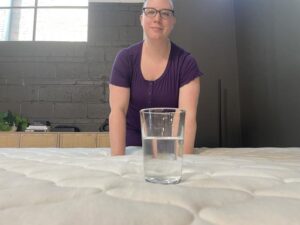 Our tester conducts a ripple test on the WinkBed EcoCloud Hybrid Mattress