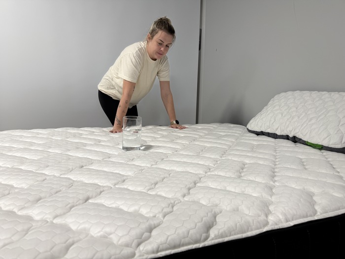 Testing motion isolation on the Titan Plus Core mattress with a glass of water