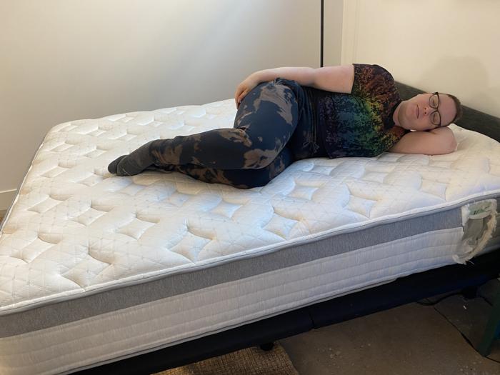 Our tester side-sleeping on the Helix Plus Mattress